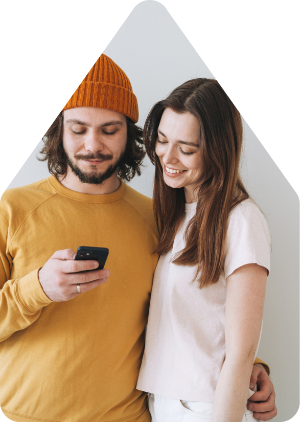 Couple looking at mobile phone for selling their house